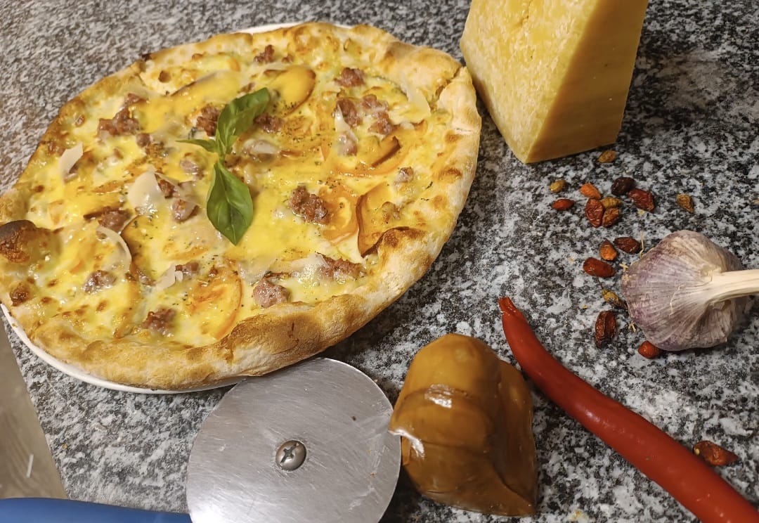 Wood-fired white pizza with sausage and smoked cheese, Parmesan, garlic and chili peppers
