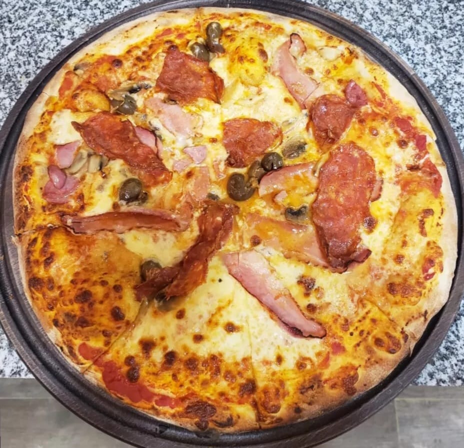 Wood-fired pizza with salami, ham, mushrooms and olives